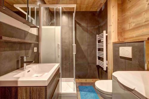 La salle de bains est pourvue d'un lavabo, d'une douche et de toilettes. dans l'établissement Beauregard 2, au Grand-Bornand