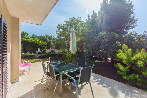 a patio with a table and chairs and an umbrella at Merlini in Medulin