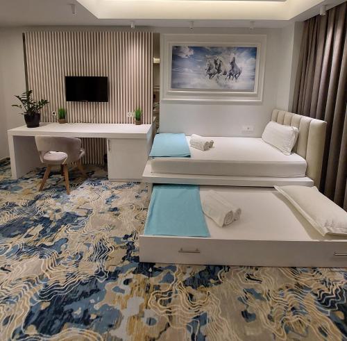 Cette chambre comprend deux lits et un bureau. dans l'établissement Apartments Jordan Luxury, à Gevgelija