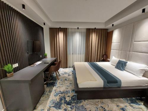 a hotel room with a bed and a desk at Jordan Luxury in Gevgelija