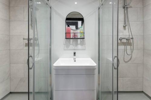 a white bathroom with a sink and a shower at Luxury Mirror Party Pad with 4 Bedrooms! Silent Disco Package included in Liverpool