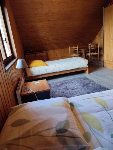 - une chambre avec 2 lits, une table et un canapé dans l'établissement Chambre d'hôtes à la campagne 