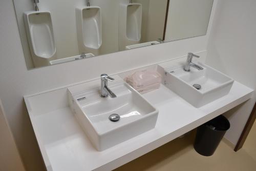 a white bathroom with two sinks and a mirror at 1 Night 1980 Hostel Tokyo Asakusa Simple Stay in Tokyo