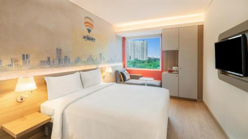 Habitación de hotel con cama blanca y TV en ibis Thane - An Accor Brand en Thane