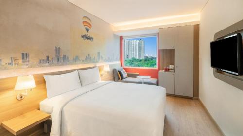 a hotel room with a white bed and a tv at ibis Thane - An Accor Brand in Thane