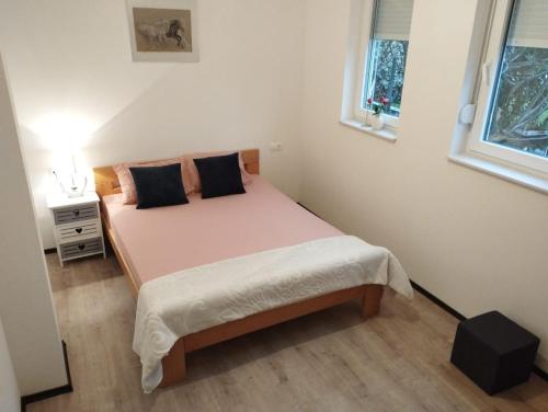 ein Schlafzimmer mit einem Bett und zwei Fenstern in der Unterkunft Hercegovina Rent in Ljubuški