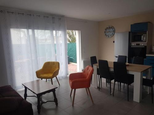 a living room with a dining room table and chairs at Maison au calme 2 à 300 m de la plage 2 chambres in La Cotinière