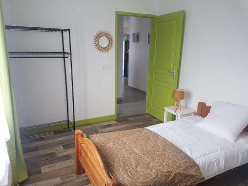 1 dormitorio con cama y puerta verde en Maison au calme 2 à 300 m de la plage 2 chambres en La Cotinière