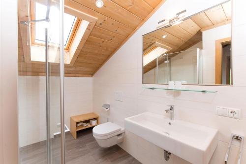 ein Badezimmer mit einem Waschbecken, einem WC und einem Spiegel in der Unterkunft Appartement Riederhof in Saltaus