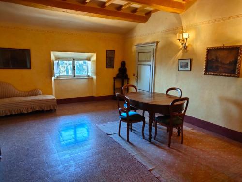 um quarto com uma mesa e cadeiras e um sofá em Villa Bellaria em Campagnatico