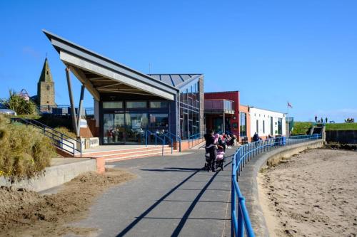 a person riding a scooter on a sidewalk next to a building at Witheys Lodge in Woodhorn