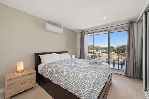 a bedroom with a bed and a large window at The Shoal in Shoal Bay