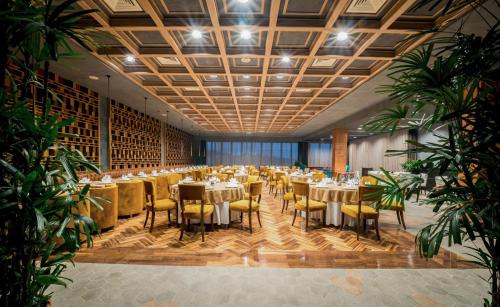 Un gran salón de banquetes con mesas y sillas. en Les Ambassadeurs Hotel Casino&Marina, en Kyrenia