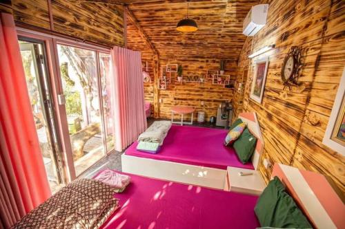 Habitación con cama morada en una cabaña de madera. en Roses Villa Tam Dao - Venuestay, en Tam Ðảo