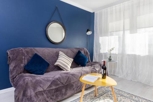 a living room with a purple couch and a mirror at Przymorze Falowiec Apartment by Renters in Gdańsk