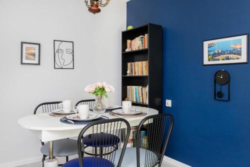 a dining room with a white table and chairs at Przymorze Falowiec Apartment by Renters in Gdańsk