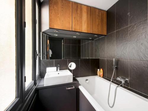 une salle de bain avec un lavabo et une baignoire dans l'établissement Jehan, à Paris