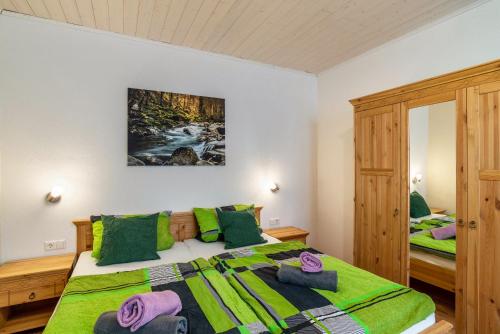 a bedroom with a large bed with green pillows at Am Sersbach in Forbach