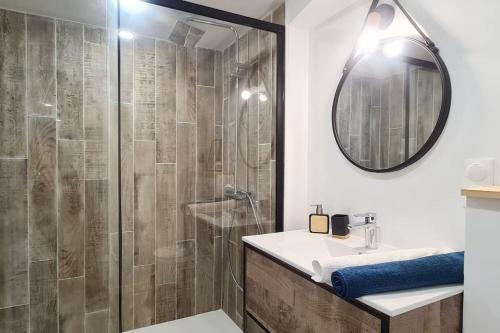 a bathroom with a shower and a sink and a mirror at L'Atelier d'Emilie in Bessines