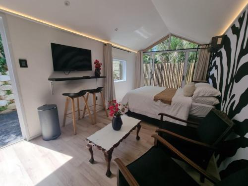 1 dormitorio con cama, escritorio y piano en Unique Pod Stay, en Durban