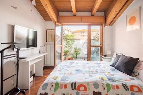 um quarto com uma cama grande e uma televisão em Le Domus Milano_Attic with terrace em Milão