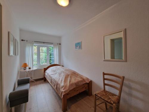 una camera con un letto e una sedia e una finestra di Teich-11b a Grossenbrode
