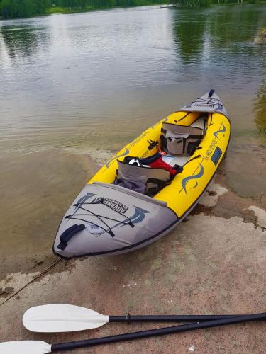 a yellow kayak sitting on the shore of a lake at Guesthouse Torppa in Korkeakoski