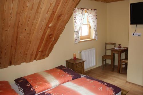 a bedroom with a bed and a window at Koliba u Kuba a rekreačné domy in Hruštín