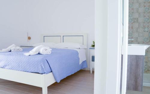 a white bedroom with a bed and a sink at Don Pietro Vacanze in Policoro
