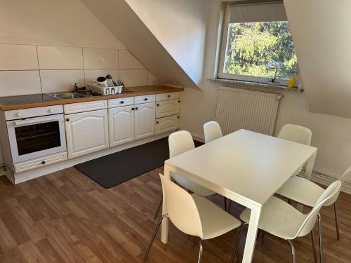 una cucina con tavolo e sedie bianchi di Apartment for rent 1 a Celle