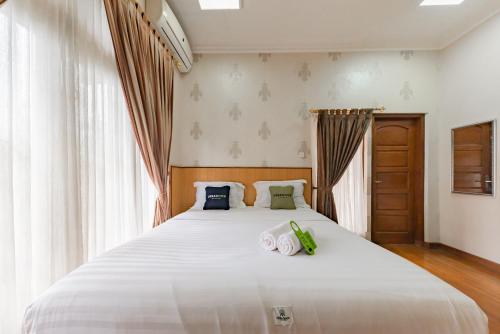 Кровать или кровати в номере Urbanview Hotel Villa Surya Bandung
