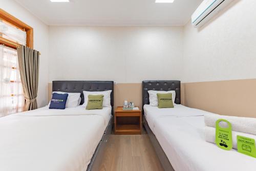 Ένα ή περισσότερα κρεβάτια σε δωμάτιο στο Urbanview Hotel Villa Surya Bandung