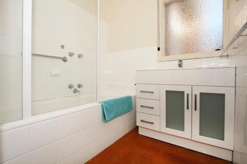ein weißes Bad mit einer Badewanne und einer Dusche in der Unterkunft Lisson Holiday Rental in Melbourne