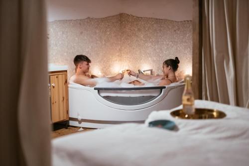 2 persone in una vasca da bagno in una camera da letto di Obiralmhütte Mosgan a Bad Eisenkappel