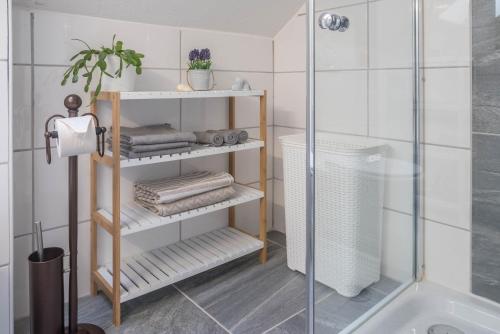 a bathroom with a shower and a shelf with towels at Ferreira's Loft - Ferienwohnung in St. Blasien