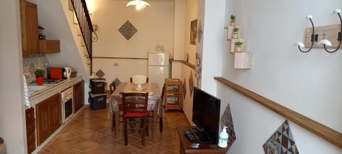 a small kitchen with a table and a refrigerator at Casa Vacanze Chiara in Terrasini