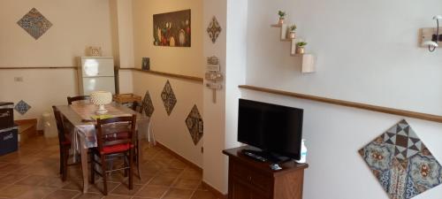 un soggiorno con tavolo da pranzo e TV di Casa Vacanze Chiara a Terrasini