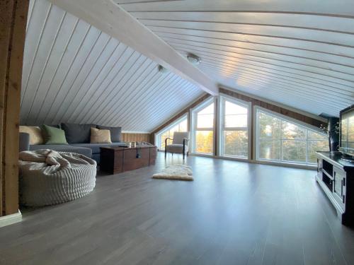 a living room with a couch and some windows at Cabin with sauna in Trysil in Trysil