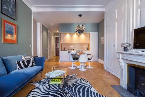 uma sala de estar com um sofá azul e uma lareira em Confort - T3 rental - Lyon 2 em Lyon