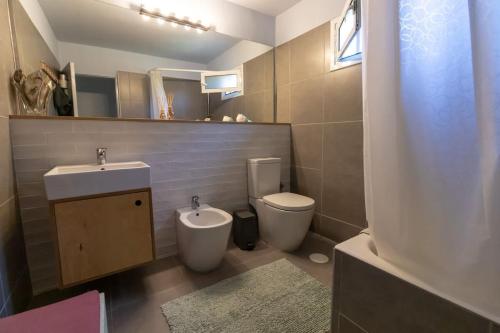 a bathroom with a sink and a toilet and a mirror at Summer front sea house for a relaxing get-away! in Pýrgos