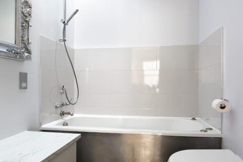 a white bathroom with a tub and a toilet at Stunning flat in Notting Hill with roof top in London