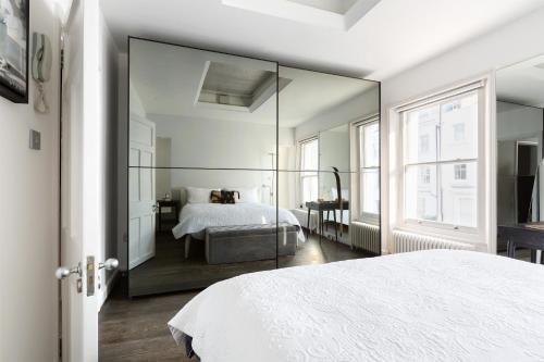 a large mirror in a bedroom with a bed at Stunning flat in Notting Hill with roof top in London