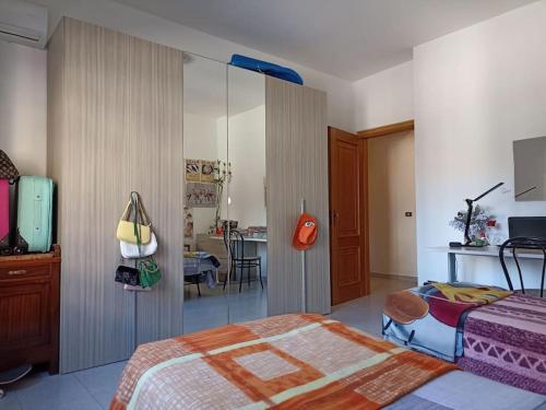 een slaapkamer met een bed en een kamer met een tafel bij Appartamento incantevole con parcheggio custodito in Roccella Ionica