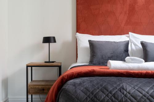 a bedroom with a bed with a red headboard at Chapel Apartment in Dunedin