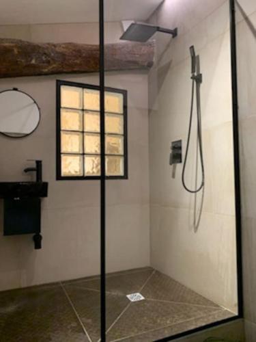 une douche avec une porte vitrée dans une salle de bain dans l'établissement Cœur de ville, à Perpignan