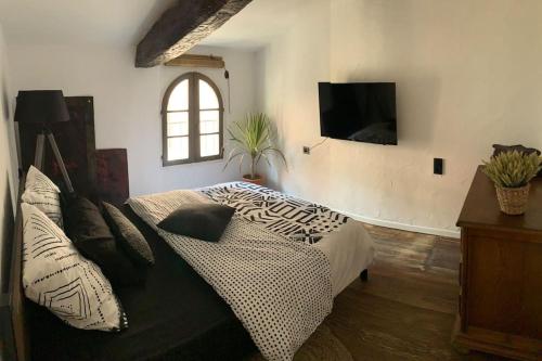 um quarto com uma cama e uma televisão na parede em Cœur de ville em Perpignan