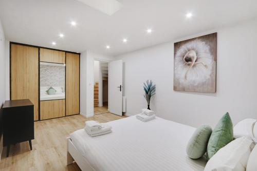 biała sypialnia z dużym łóżkiem i obrazem na ścianie w obiekcie Pick A Flat's Apartment in La Chapelle - Impasse du Curé w Paryżu