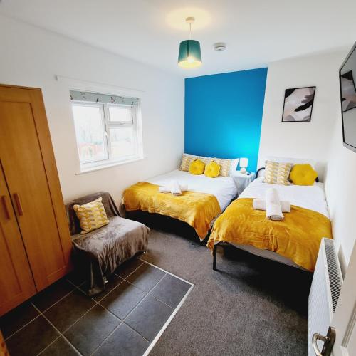 a room with two beds and a chair in it at Sheridan House - En-suite Bedrooms I Long or Short Stay I Special Rate Available in Derby