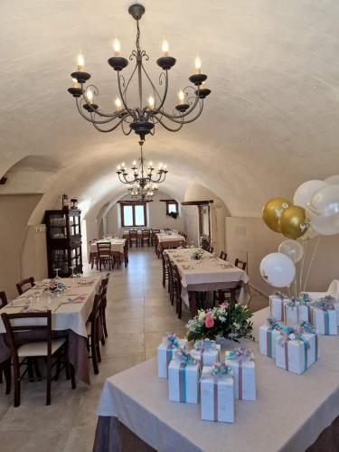 a dining room with tables and chairs and a chandelier at Il pozzo dei desideri in Castelnuovo