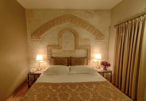 a bedroom with a large bed with two lamps at Heybe Hotel & Spa in Göreme